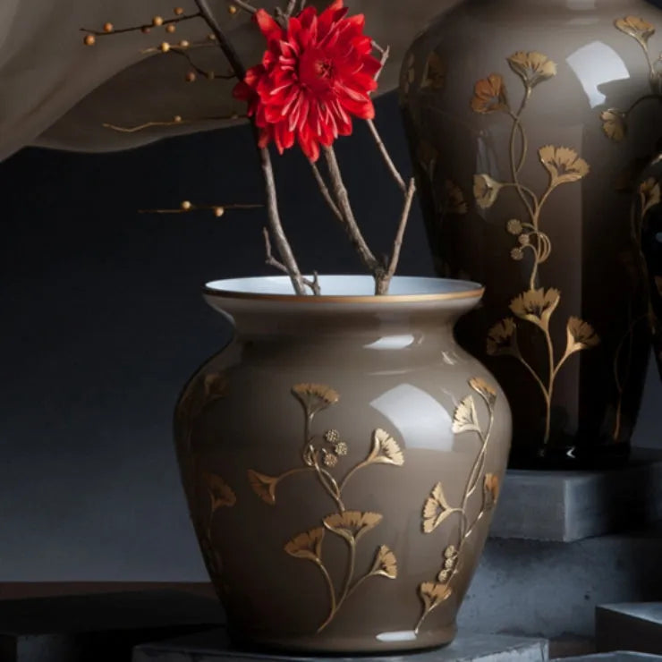 Eine braune Opalglasvase mit goldenen Ginkgoblättern handbemalt