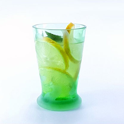 hellgrünes Glas mit dekorativem Muster gefüllt mit Zitronenlimonade