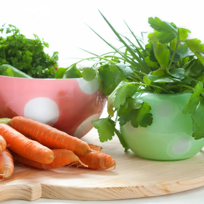 bunte Vase und Schale mit Gemüse und Kräutern